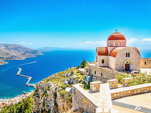 Conozca el típico paisaje costero de Grecia con mar, montañas, bahías y capilla en la montaña con Yates Europa 