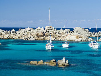 Anchoring in turquoise waters off bizarre rocks in Lavezzi, from Costa Esmeralda charter base with Yates Europa 
